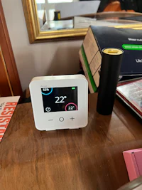 a digital thermosta sitting on a wooden table