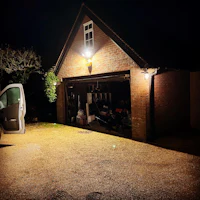 a car is parked in front of a garage at night