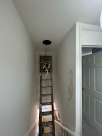 a ladder in a hallway with a light on it